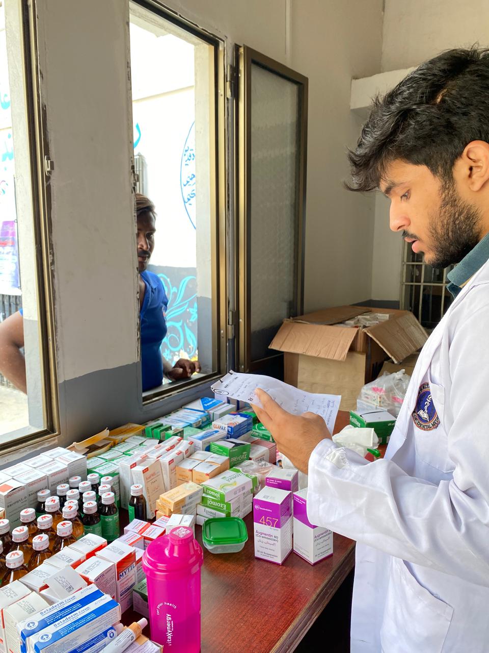 Doctor dispensing medicines at counter